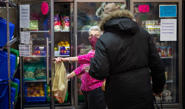 Janie Baron helps a client at the Senior Food Shelf in northeast Minneapolis on Wednesday, March 1. 