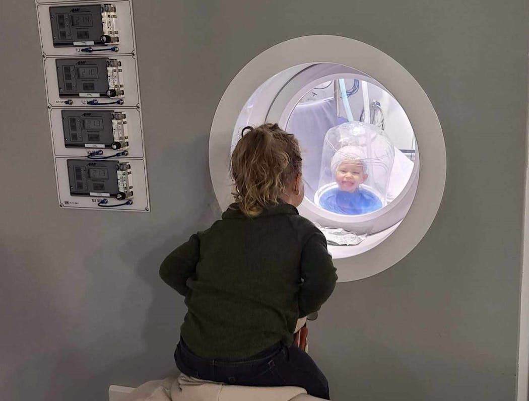 Kenzie Riemenschneider, 2, received treatment in the hyperbaric chamber at Hennepin Healthcare to help reattach a severed fragment of her ear, while her sister Kallie looked inside.