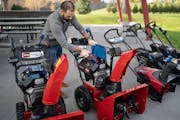 Aran Brosnan, a marketing manager for a Toro division, shows how batteries can be swapped in a new line of Toro snowblowers and lawnmowers, in this fi