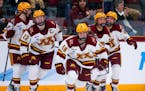Abbey Murphy (18) leads teammates back to the Gophers bench after scoring in the third period as Minnesota took a 2-0 lead over Minnesota Duluth.