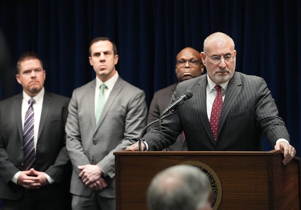 U.S. Attorney Andrew Luger, right, at podium, announced Monday charges against 10 more people in the ongoing $250 million federal food aid fraud case 