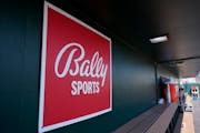 A Bally Sports logo is in the dugout during a spring training baseball game.