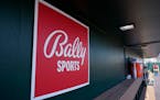 A Bally Sports logo is in the dugout during a spring training baseball game.