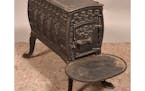 This cast-iron wood stove kept a 19th-century room warm. Its embossed designs, especially the rows of pointed arches on its sides, were meant to evoke