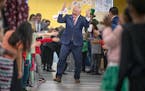 Gov. Tim Walz was greeted by Webster Elementary students in Minneapolis before signing a bill Friday that guarantees free school meals for every stude