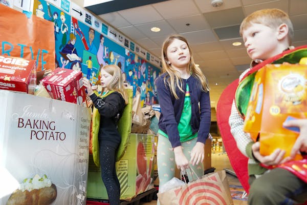 Annie Zechmeister, 9, Zoey Hasek, 8, and Jacob Zechmeister, 7, from left, on Friday helped unload bags collected from a weeklong food drive for the IC