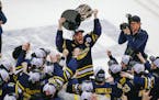 Michigan’s Nolan Moyle holds the Big Ten tournament trophy after the team’s win over the Gophers on Saturday.