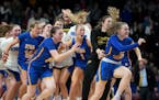 St. Michael-Albertville players celebrate their thrilling 71-70 win over Hopkins’ Kelly Boyle  Saturday, March 18, 2023 during the first half of the