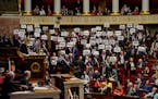 Far-left lawmakers react as they hold papers reading: “64 years. It is no” at the National Assembly in Paris at the National Assembly in Paris, Mo