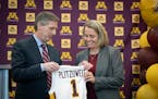 University of Minnesota Athletic Director Mark Coyle, left, introduces Dawn Plitzuweit as the new women’s basketball coach during a news conference 