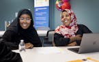 Hafsa Abdi, 22, with the Shakopee Community Resource Center and Zahra Yasin, 28, with Isuroon helped a community member with some legal forms Monday a