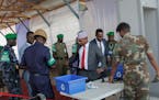 Somali lawmakers are checked by security forces as they arrive to cast their vote in the presidential election, at the Halane military camp which is p