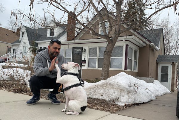 John Sibilia and his dog, Gunnar, at their new house in West St. Paul. After paying more than the $225,000 asking price, the sellers helped pay some o