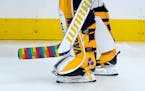 FILE - Los Angeles Kings goaltender Calvin Petersen (40) holds a stick wrapped in rainbow tape for Pride night while warming up before an NHL hockey g