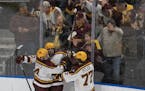 Gophers forward Connor Kurth (10) was congratulated by teammates Mike Koster (4) and Rhett Pitlick (77) after Kurth scored the go-ahead goal in the se