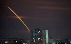 Russian rockets launched against Ukraine from Russia’s Belgorod region streak across the sky at dawn in Kharkiv, Ukraine, early Friday, March 24, 20