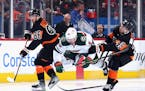 Noah Cates (49) of the Flyers tripped Wild’s Marcus Johansson on Thursday in Philadelphia. The Flyers won 5-4 in overtime.
