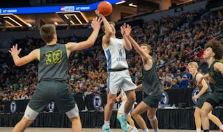 Russell-Tyler-Ruthton senior Aiden Wichmann shot a floater over New Life Academy defenders Saturday at Target Center. Wichmann scored 18 points in his