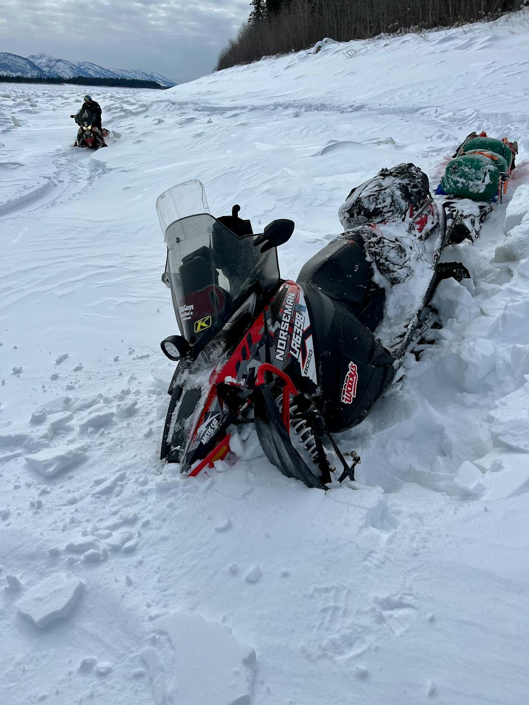 The trek was not an easy one; here one of the snowmobiles was stuck in the deep snow Friday, one of many times the trio found their journey stalled by the conditions.