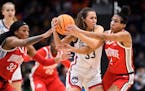 UConn guard Caroline Ducharme holds onto the ball as Ohio State’s Cotie McMahon and Taylor Thierry (2) attempt to steal possession during the second