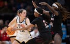 Iowa guard Caitlin Clark looked to pass against Louisville guard Morgan Jones, center, and forward Olivia Cochran. Clark had a triple-double in the Ha