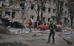 Communal workers clean the debris from the street in front of a heavily damaged building after a Russian attack in Sloviansk, Donetsk region, Ukraine,