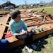 Robbie Diffey sits on top of the roof of her garage after a tornado destroyed the home she’s lived in for 38 years, Monday, March 27, 2023, in Rolli