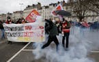 A protester throws an item during a demonstration Tuesday, March 28, 2023 in Nantes, western France. The fresh wave of strikes and protests is the 10t