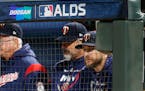 Minnesota Twins manager Rocco Baldelli, right, watches from the dugout during the eighth inning in Game 3 of a baseball American League Division Serie