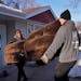Two Men and a Truck movers carried a couch to a truck on Wednesday in Shoreview. For the second year in a row, more people left Hennepin and Ramsey co
