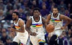 Minnesota Timberwolves guard Anthony Edwards (1) starts a fast break, trailed by teammates, guard Mike Conley (10) and center Rudy Gobert (27) in the 