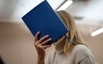 Actor Gwyneth Paltrow shields her face with a blue notebook as she exits a courtroom on March 21, 2023, in Park City, Utah. 