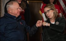 Minnesota Gov. Tim Walz fist-bumped with former U.S. Rep. Gabrielle Giffords during a news conference Thursday at the State Capitol in St. Paul.