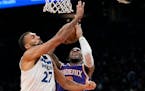 Suns forward Josh Okogie, right, was fouled by Wolves center Rudy Gobert during Phoenix’s victory on Wednesday night.