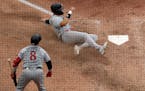 Minnesota Twins’ Trevor Larnach slides home to score on an RBI single hit by Donovan Solano during the sixth inning of an opening day baseball game 