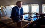 Former President Donald Trump speaks to reporters aboard his private plane in January. On Thursday, a grand jury in New York voted to indict Trump on 