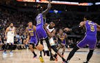 Timberwolves guard Anthony Edwards loses the ball as he collides with Lakers forward Wenyen Gabriel in the first quarter Friday.