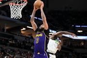 Lakers forward Anthony Davis dunks the ball against the Timberwolves in the fourth quarter Friday.