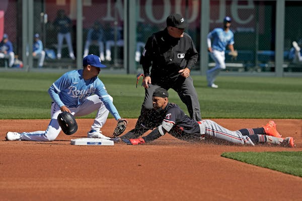 Byron Buxton beat the tag by Royals second baseman Nicky Lopez after hitting a double during the first inning Saturday