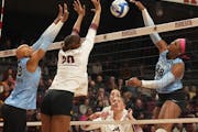 Taylor Reid of Athletes Unlimited (No. 28 in blue) went up for an attack as current Gopher Arica Davis (No. 20 in white) and Deja McClendon (No. 18 in