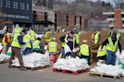 Volunteers filled sandbags in downtown Stillwater Monday, March 27, 2023 in Stillwater, Minn. After a winter of record-breaking snowfalls that could l