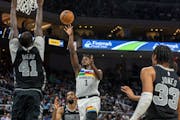 Timberwolves guard Anthony Edwards scored between Spurs center Gorgui Dieng and guard Tre Jones during the first half Saturday in Austin, Texas.