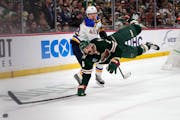 Wild defenseman Jake Middleton falls while reaching for the puck against St. Louis Blues right wing Kasperi Kapanen during the second period Saturday