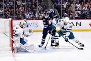 The Jets’ Mason Appleton battled for the puck with the Sharks’ Mario Ferraro in front of San Jose goalie James Reimer on Monday night.