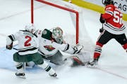 Wild goalie Filip Gustavsson (32) made a save Monday night against the Blackhawks’ Reese Johnson (52) while teammate Calen Addison (2) defended.