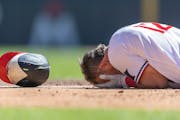 Kyle Farmer fell to the ground after he was hit in the face by a pitch in Wednesday’s Twins game.