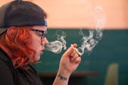 Alex Moats smokes while doing work at Hot Box Social in Hazel Park, Mich. Hot Box is the state’s first cannabis smoking lounge.