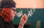 Alex Moats smokes while doing work at Hot Box Social in Hazel Park, Mich. Hot Box is the state’s first cannabis smoking lounge.