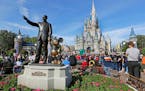 A statue of Walt Disney and Micky Mouse stands in front of the Cinderella Castle at the Magic Kingdom at Walt Disney World in Lake Buena Vista, Fla., 
