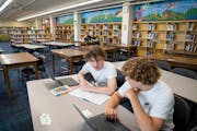 Eighth-graders Sully Moseley, right, and J.J. Keating worked on book reports at the library in Anthony Middle School in Minneapolis. Before parent vol